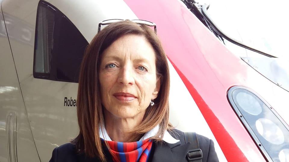 Thomasina Müller en mondura davant ina locomotiva.
