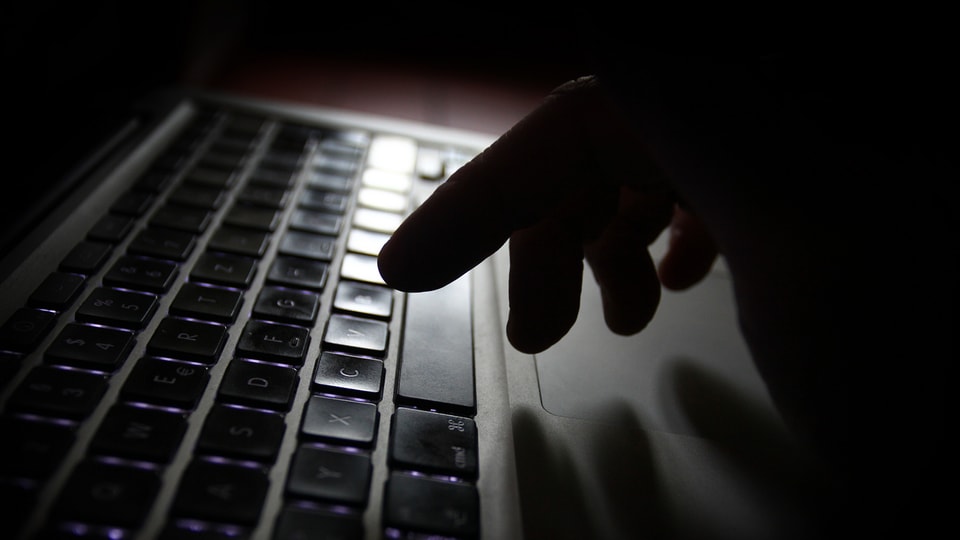 Purtret d'in maun che scriva vid ina tastatura d'in computer. 