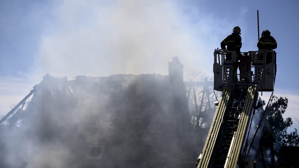 Das abgebrannt Haus in Yverdon-les-Bains mit zwei Feuerwehrleuten auf einer Leiter