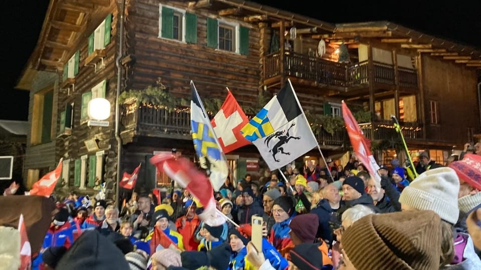 Grosse Menschenmenge schwingt Schweizer und Bündner Fähnchen.