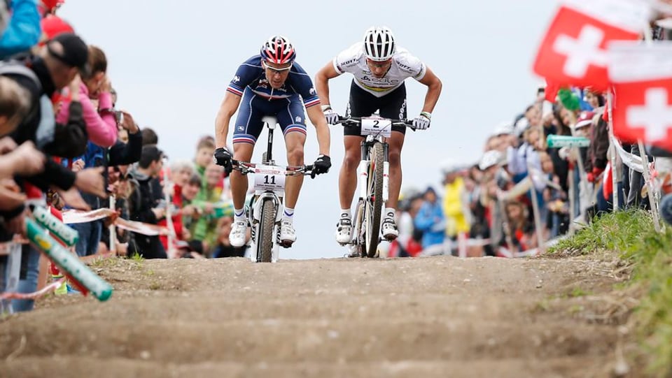 Julien Absalon e Nino Schurter en in duel tar ina cursa da mountainbike.
