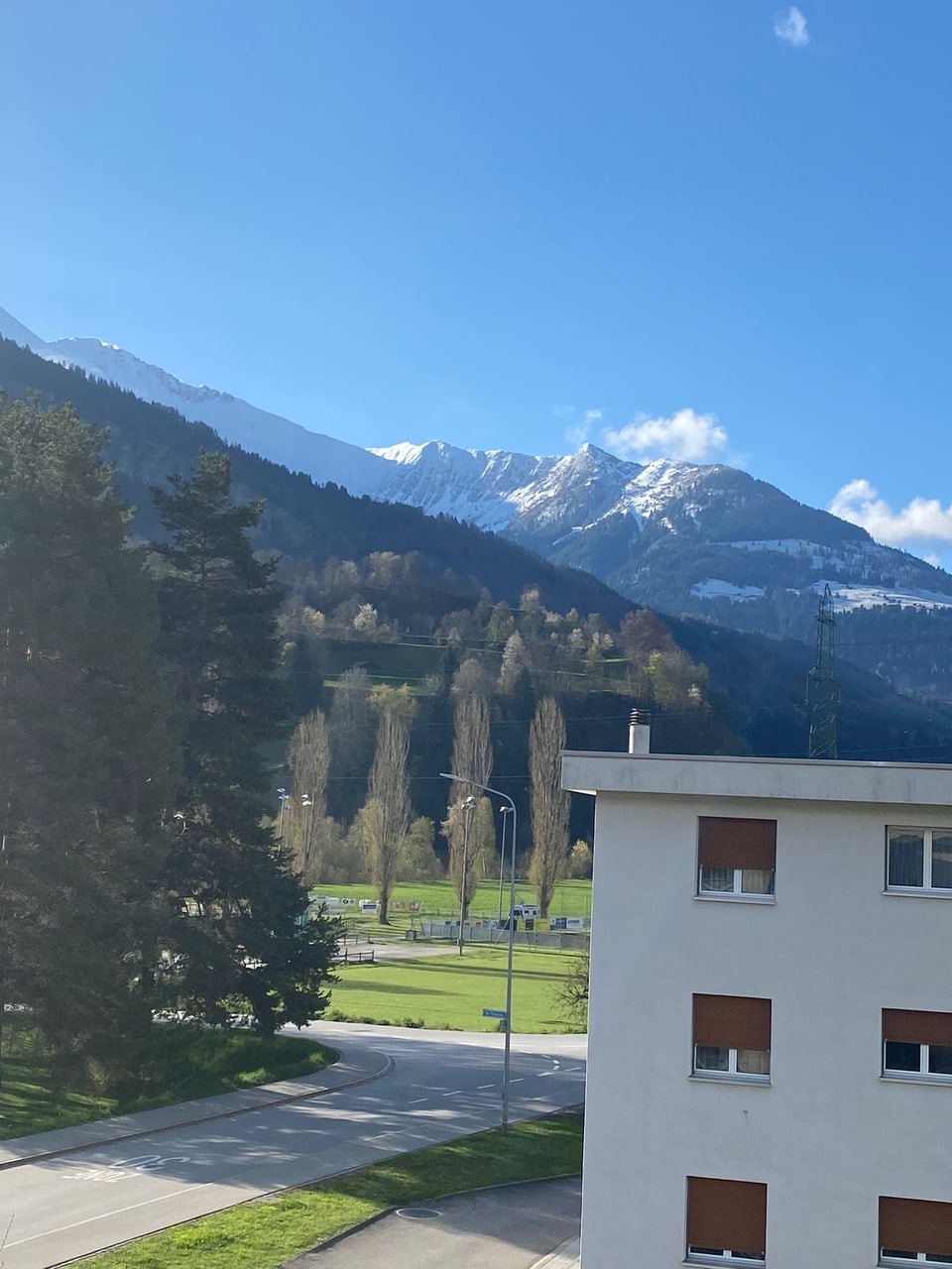 Eine Hausecke mit einem Berg im Hintergrund.