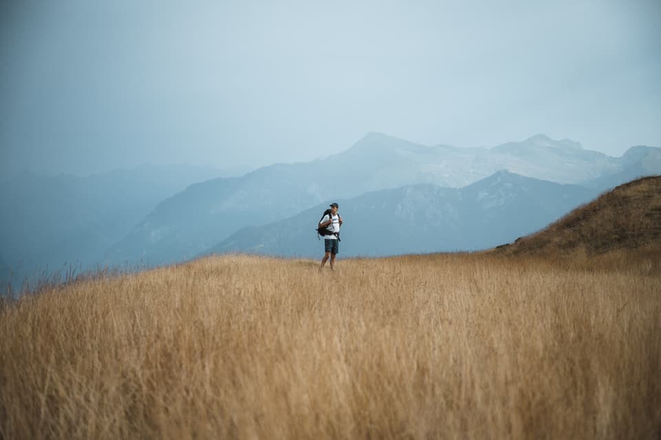 persuna sin in prà davant in panorama da muntogna