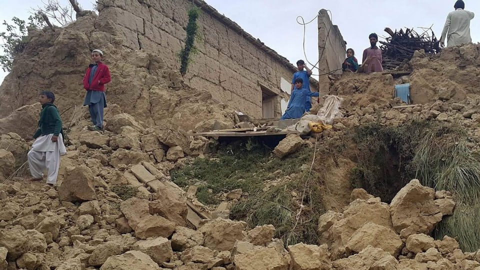 Abitants locals inspectan chasas sballunadas al cunfin tranter Pakistan ed Afghanistan.