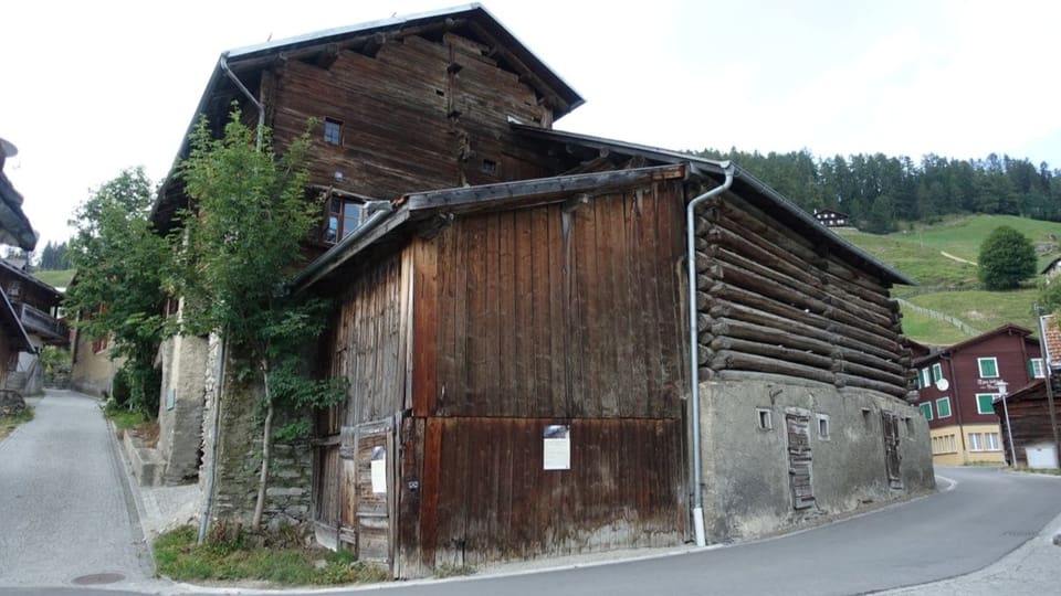 Eine Schuen verbunden mit einem Haus, das ebenfalls grösstenteils aus Holz ist.