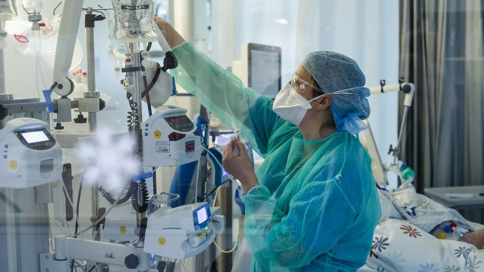 Persuna cun vestgì da protecziun en ospital. 