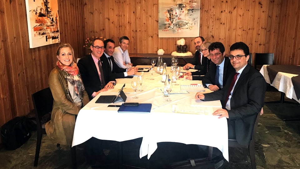 Purtret da la delegaziun cun otg persunas, mintgamain quatter da mintga vart. Ils Grischunais a sanester ed ils Tessinais da vart dretga. 