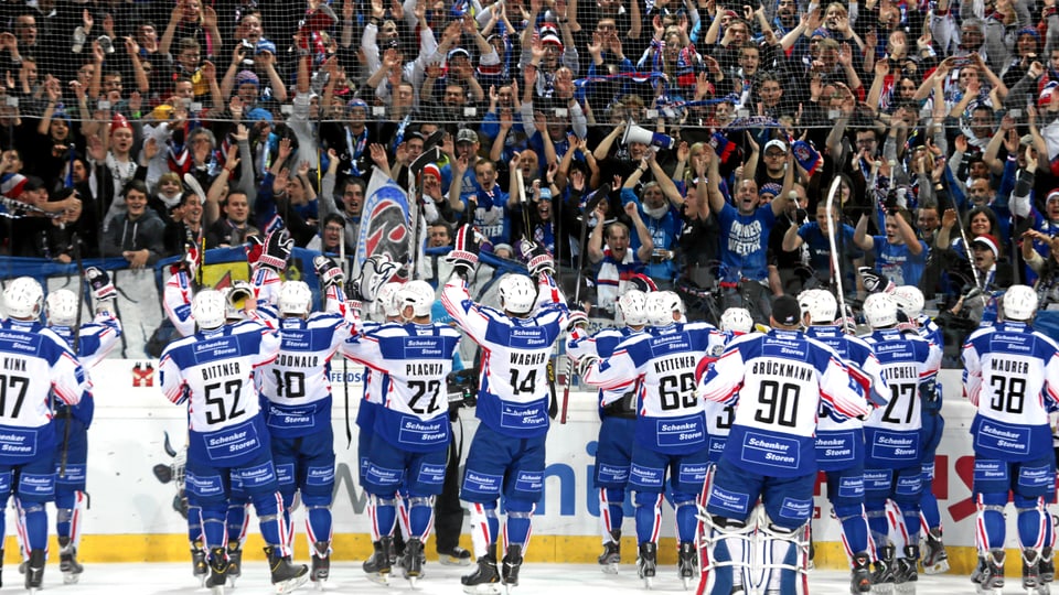 L'equipa da hockey dad Adler Mannheim vid il festivar cun ses fans.