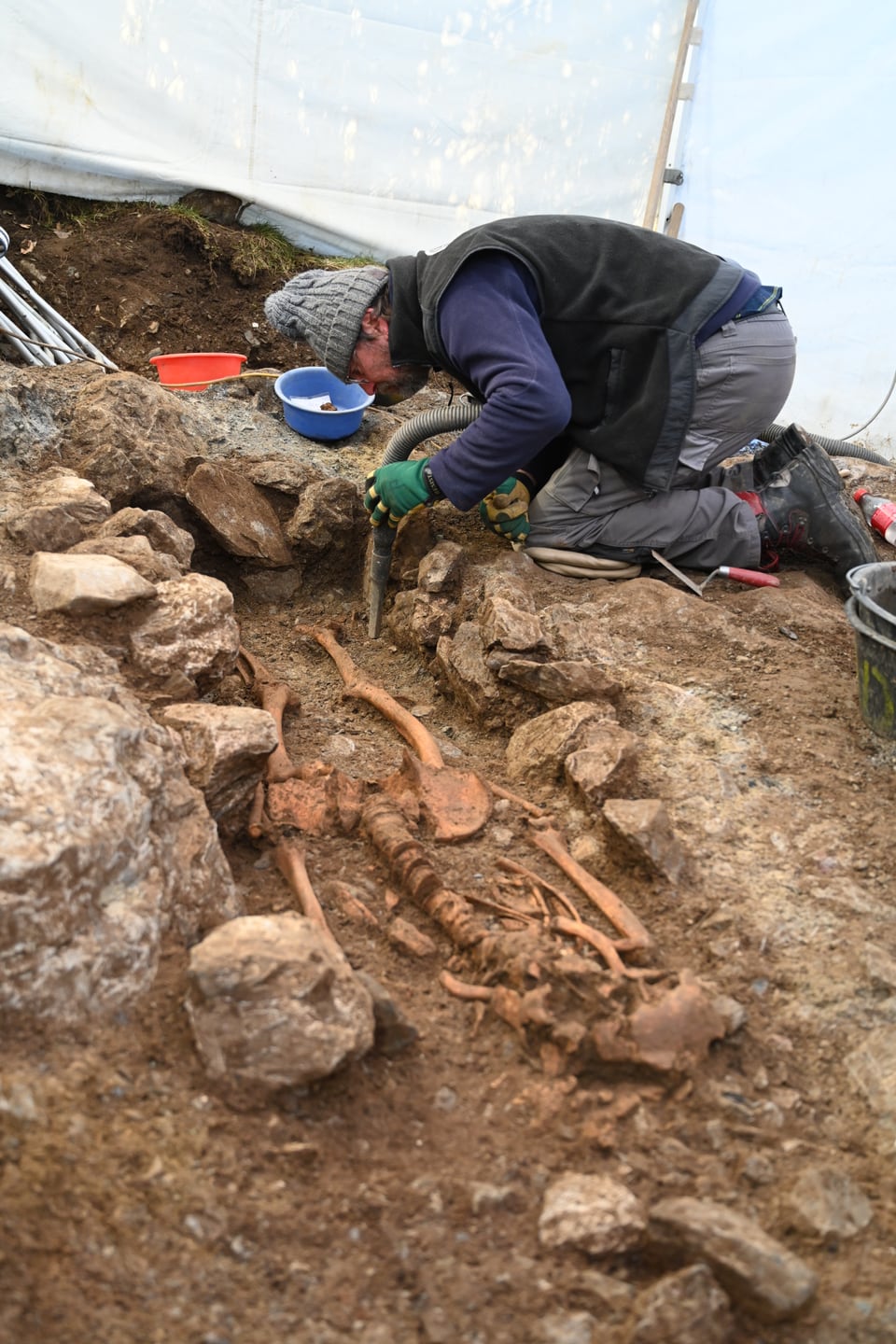 Ein Mann gräbt ein menschliches Skelett aus