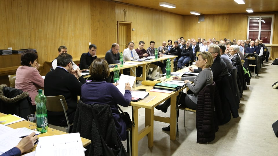 Il cussegl da vischnanca sesa enturn las maisa ed ils aspectaturs taidlan tiers