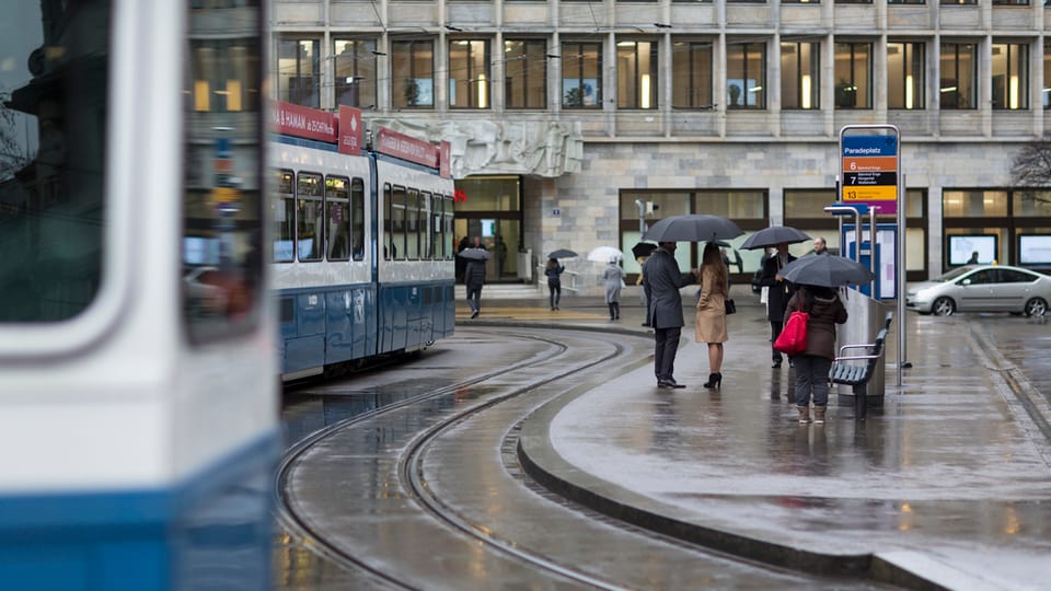 Persunas che spetgan sin il tram a Turitg.