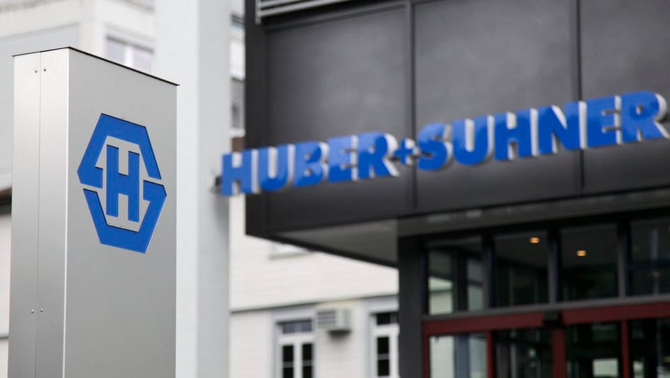 Bajetg da Huber+Suhner che mussa er il logo dal concern.