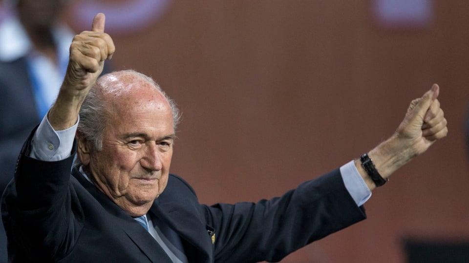 Joseph Blatter auza ils mauns e mussa ils polischs. 