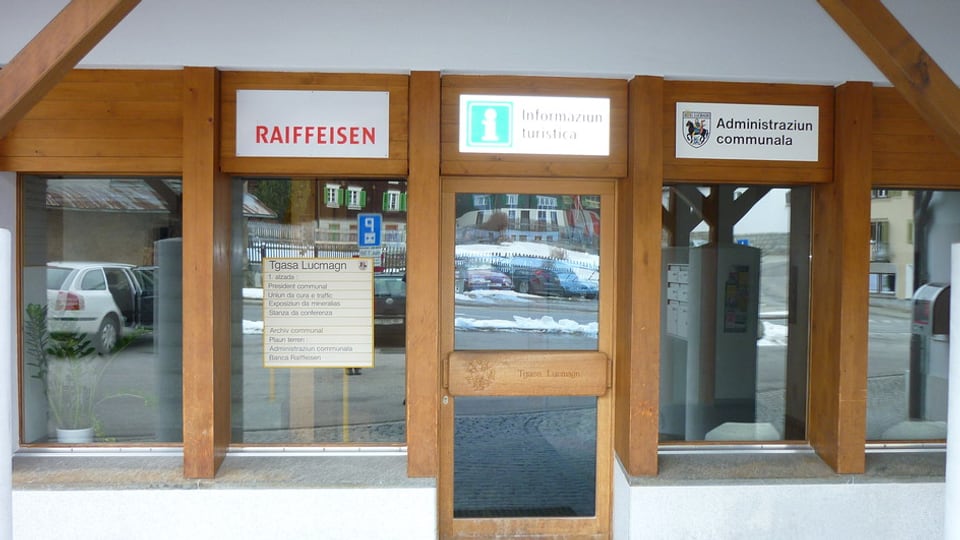 Vista da l'entrada da la filiala da la Banca Raiffeisen Cadi a Curaglia.