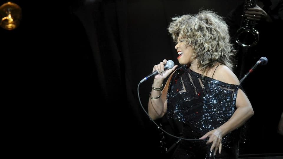 Purtret da Tina Turner durant in concert.