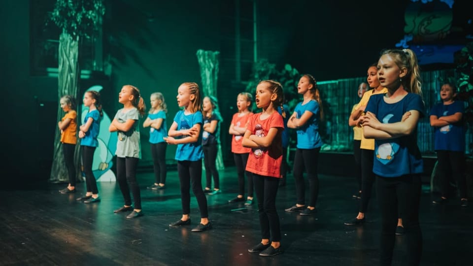 Die Kinder-Gruppe Singvögel auf der Bühne während eines Konzertes.