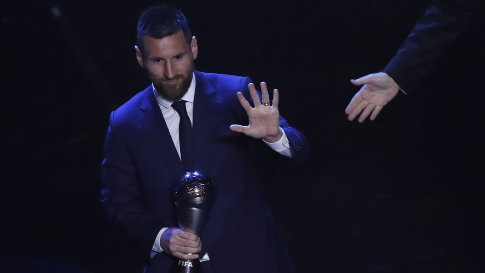 Purtet da Lionel Messi cun il premi enta maun. 