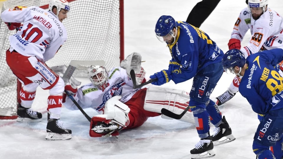 Giugader dal HCD emprova da sajettar in gol. Goalie en dies, auter hockeyan adversari dal HCD er.
