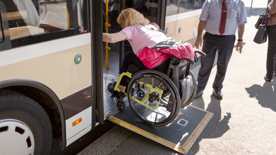 Purtret d'ina dunna cun sutga da rodas ch'entra in bus sur ina rampa. 