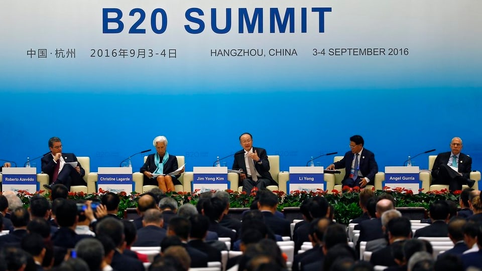 Ina runda da discussiun sin in palc sut il logo dal B20 summit.