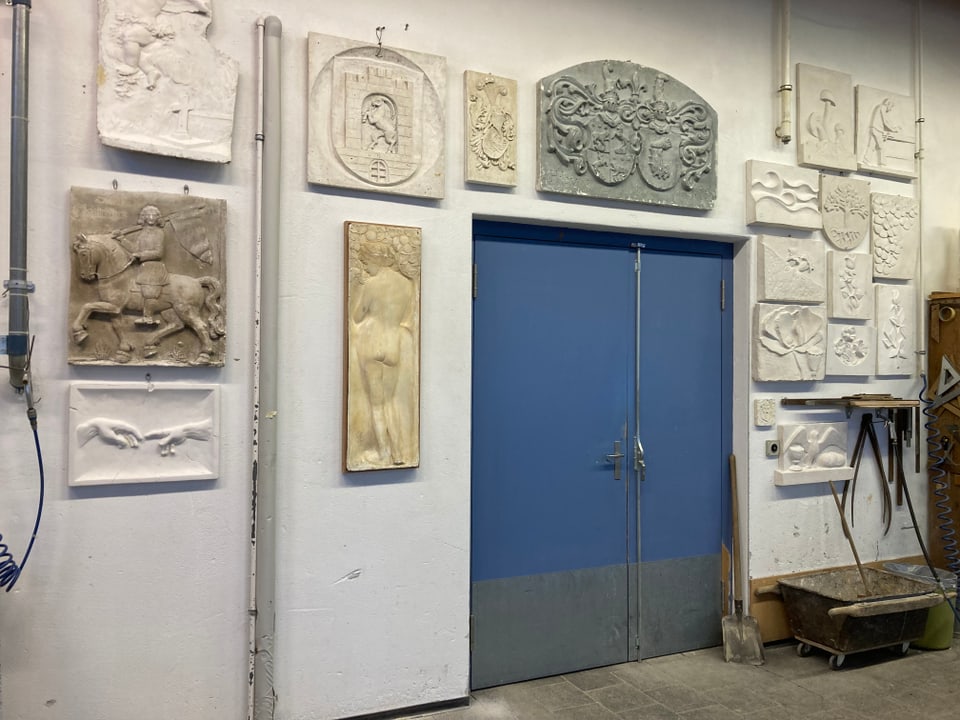 reliefs che pendan vid ina prait da lavuratori. ina porta blaua