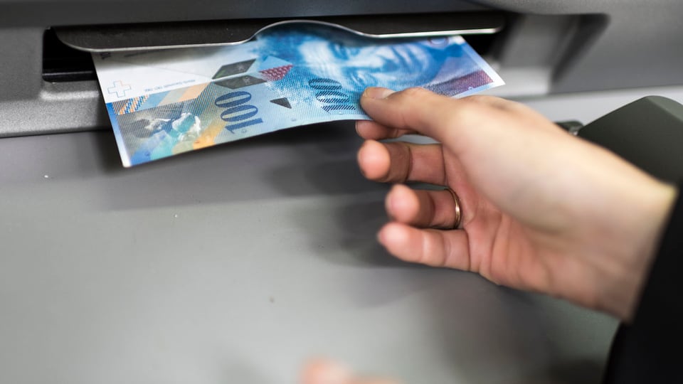 bancomat, in maun prenda la bancnota da 100 francs