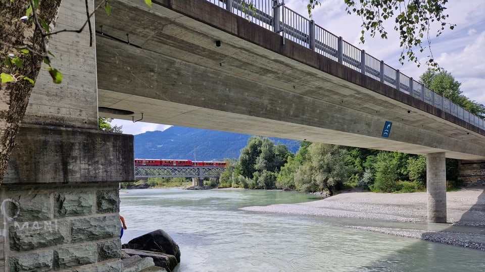 Im Vordergrund ist eine Brücke zu sehen, unter der eine weitere Brücke weiter hinten mit einer Eisenbahn sichtbar ist.
