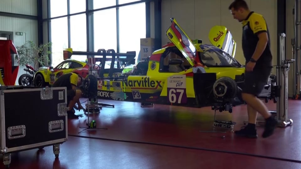 Zwei Mechaniker arbeiten an einem Rennwagen, bei T2 Racing.