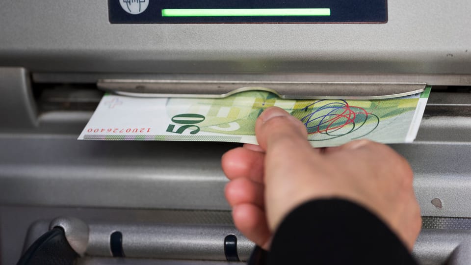 In maun che prenda ina bancnota da 50 ord in bancomat.