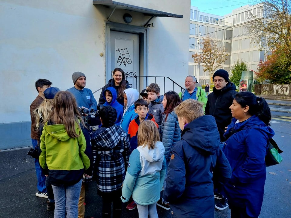 Eine Gruppe Kinder steht draussen und wartet auf den nächsten Teil eines Workshops