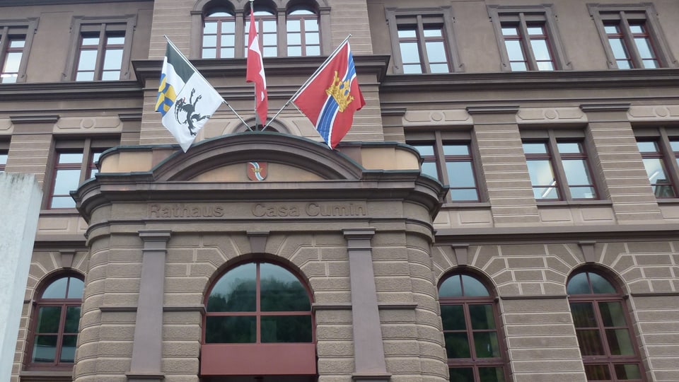 L'entrada da la chasa cumin da Glion cun las bandieras dalla Svizra, dal Grischun e da Glion. L'inscripziun sur l'entrada è "Rathaus" e "Casa Cumin".