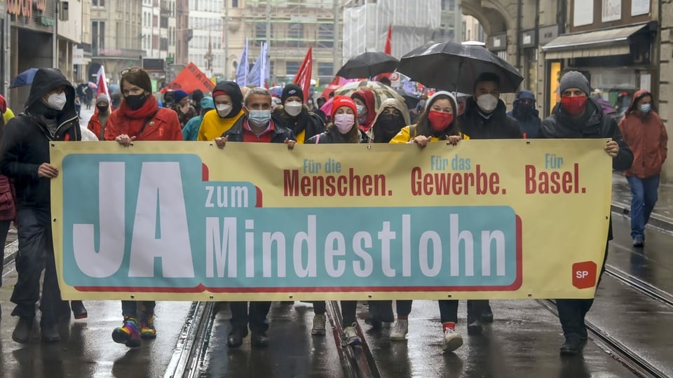 gruppa da demonstrantas e demonstrants sin via a Basilea cun in placat «Gea a la paja minimala»