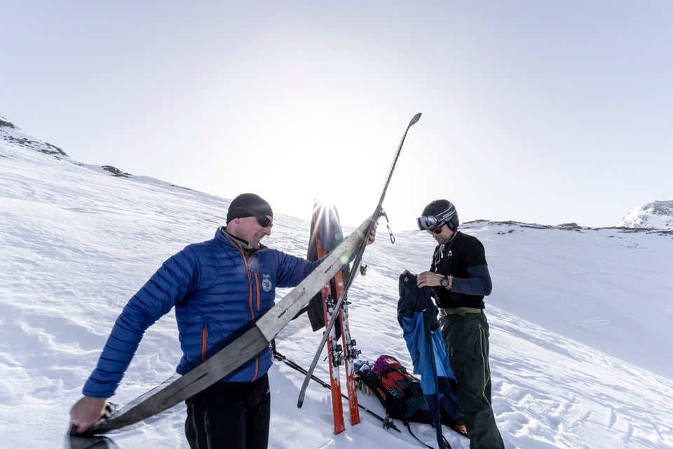 Mann zieht von Skier Fell ab