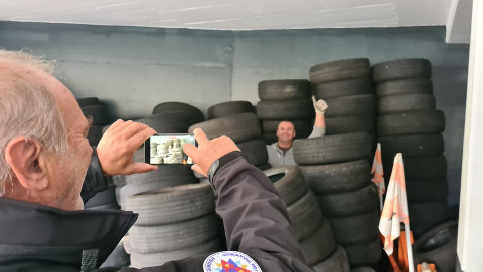 Es darf auch gelacht werden. Ein Helfer inmitten al der Pneu die bereitstehen um abtransportiert zu werden. 