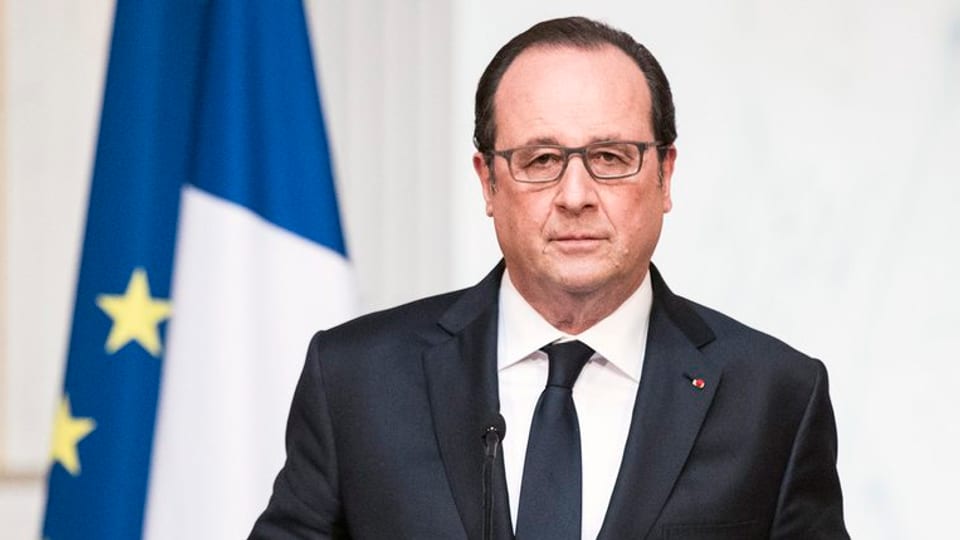 Hollande en purtret davant in microfon.