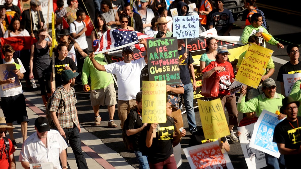 Demonstrants cun placats e bandiera americana