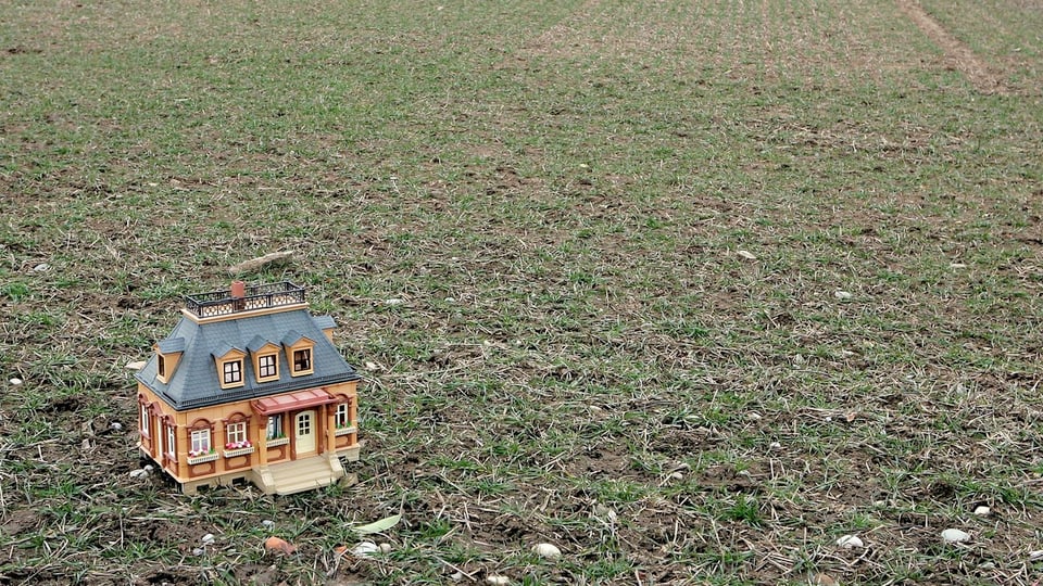 Il maletg mussa in model d'ina chasa sin in prà vit.