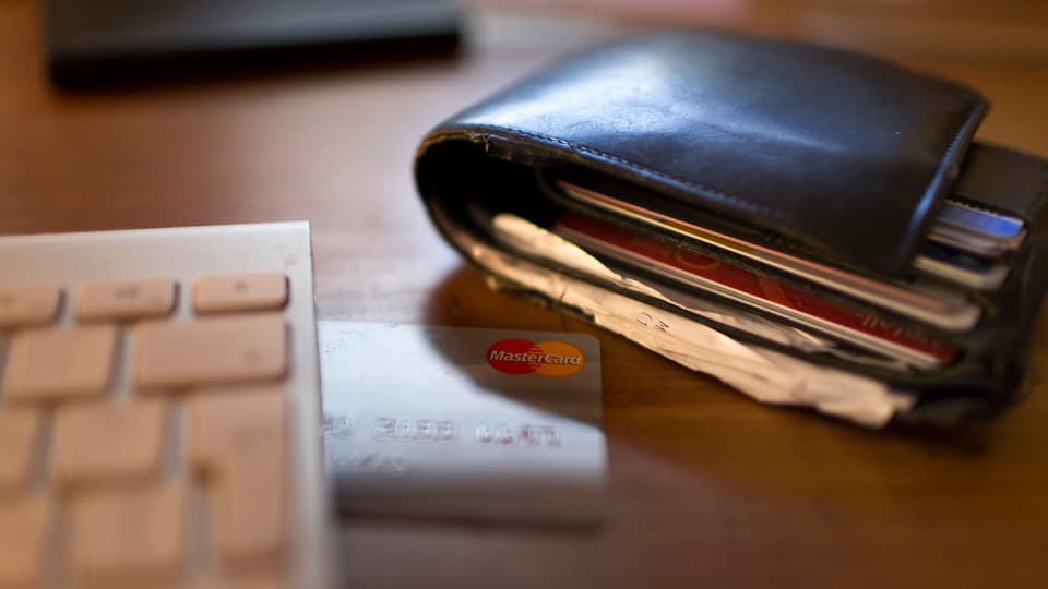 Purtret d'ina bursa e cartas da credit avant la tastatura da computer. 