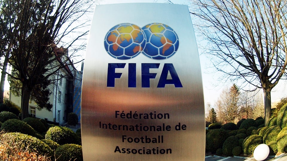 Ina platta fier cun inscrit «FIFA». Sur il logo stattan duas ballas da ballape che vesan era ora sco dus bglobs terresters.