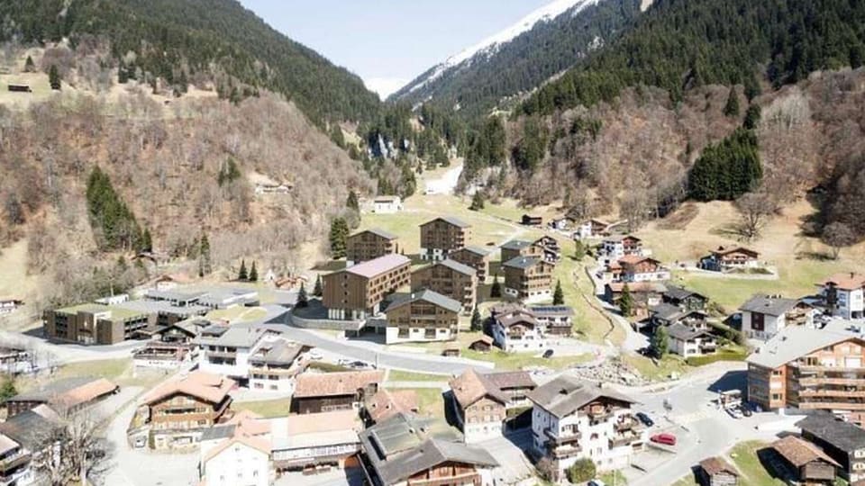La visualisaziun dad intginas chasas amez il vitg, fabritgadas en stil da chalets gronds sco usità a Claustra.