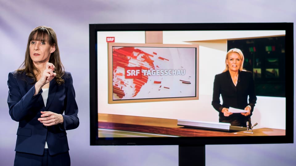 Tagesschau cun dunna che mussa la lingua da segns. 