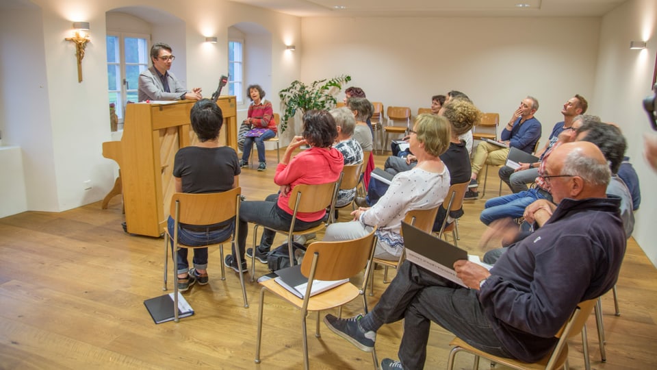 Il chor da Sagogn durant ina emprova da chant avant il temp da Corona.