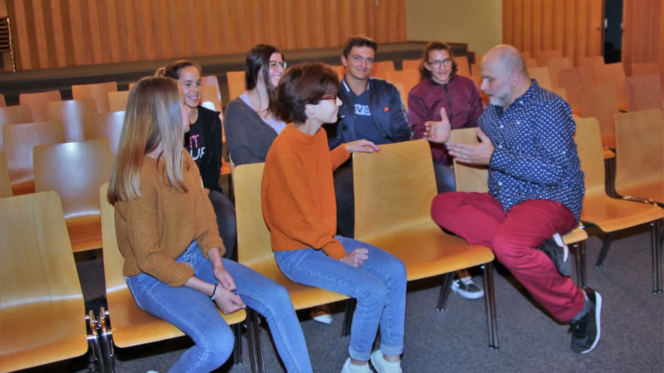 Purtret da Körner che gesticulescha ed ils 6 giuvenils interessads. 