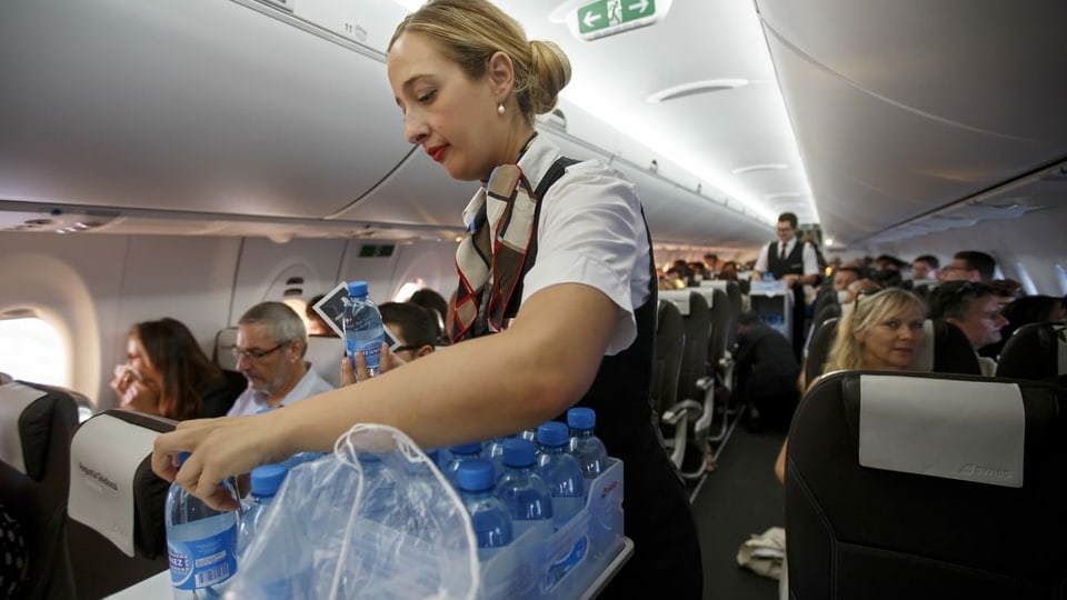Flight attendant da la Swiss che cumparta aua.