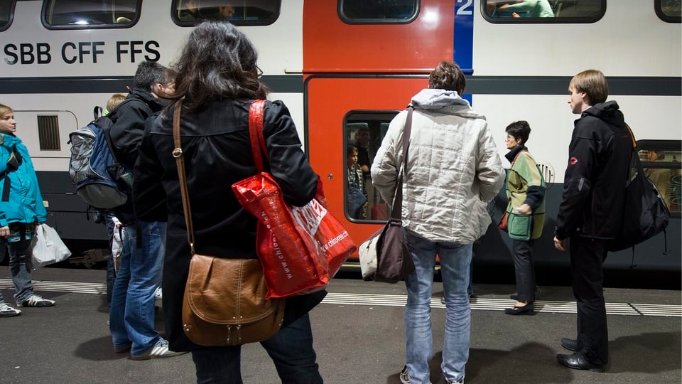 staziun da tren, pliras persunas spetgan avant in tren per entrar