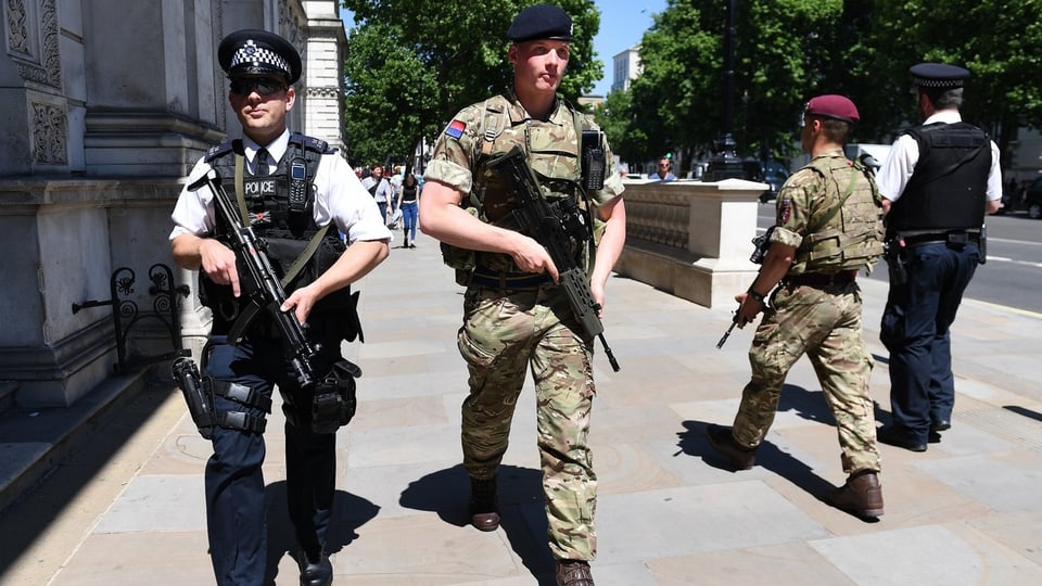 In polizist accumpignà d'in schuldà sin via en Gronda Britannia.