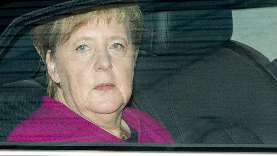 Angela Merkel sesa en in auto e guarda da fanestra or.