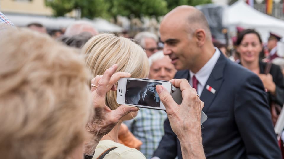 Cusseglier federal Alain Berset entamez la populaziun, ina seniora fa ina fotografia cun ses telefonin.