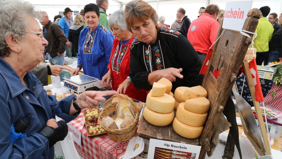 Trais puras davos il stan da chaschiel e la clientella che vul cumprar stat en retscha