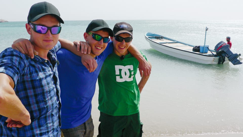Andrin, Linard und Manuel a la mar ad Oman curt avant in'excursiun da pestga.